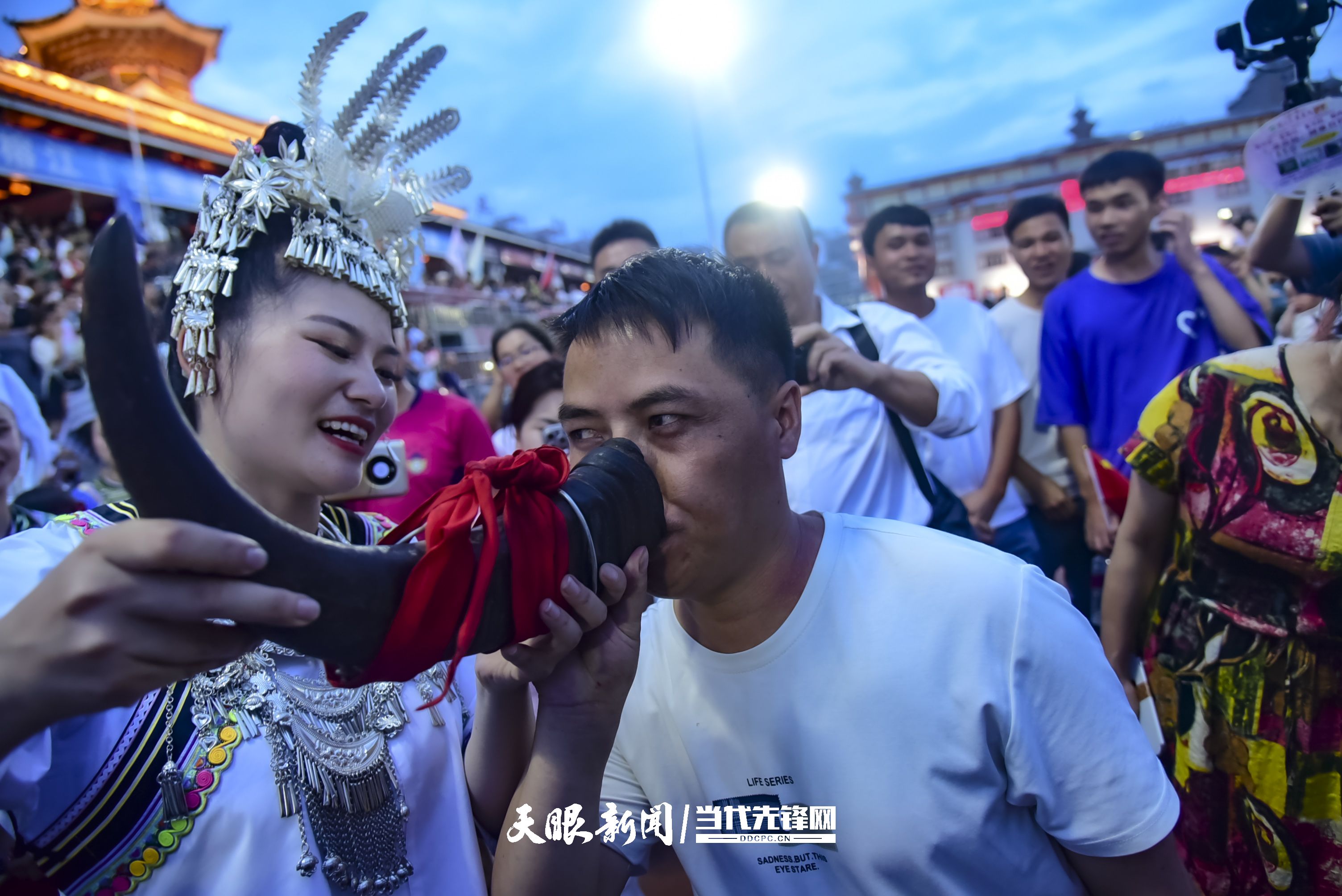村超現(xiàn)場(chǎng)，當(dāng)?shù)厝罕娤蜻h(yuǎn)道而來的游客敬酒。 潘邵平 攝.jpg