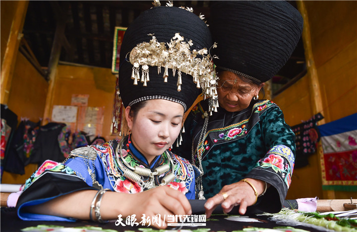 在貴州省銅仁市松桃苗族自治縣太平營(yíng)街道老寨村，一老人在指導(dǎo)繡娘繡苗繡。.jpg