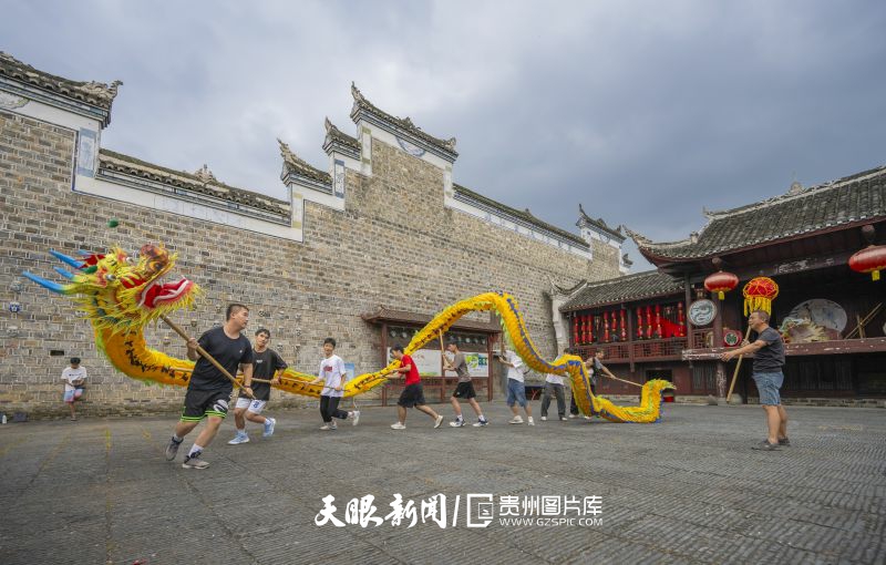 787172-8月15日，錦屏縣隆里古城中心戲臺(tái)廣場(chǎng)，縣內(nèi)優(yōu)秀學(xué)生在民間藝人的指導(dǎo)下，現(xiàn)場(chǎng)舞動(dòng)“花臉龍”的樂(lè)趣。.jpg